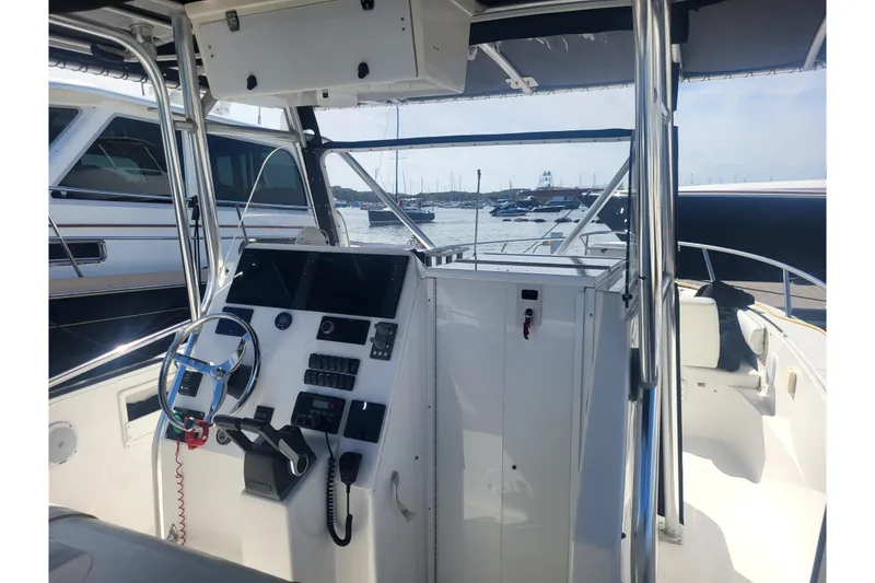 Slide: The Image of 2005 Stamas 310 Tarpon boat interior with steering wheel and control panel, docked at marina. - 67