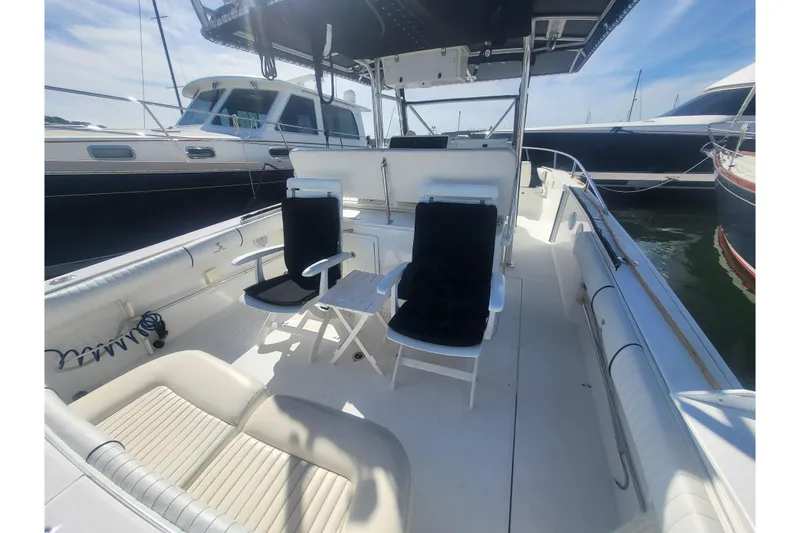 Slide: The Image of 2005 Stamas 310 Tarpon boat interior with seating and table, docked alongside other boats. - 77