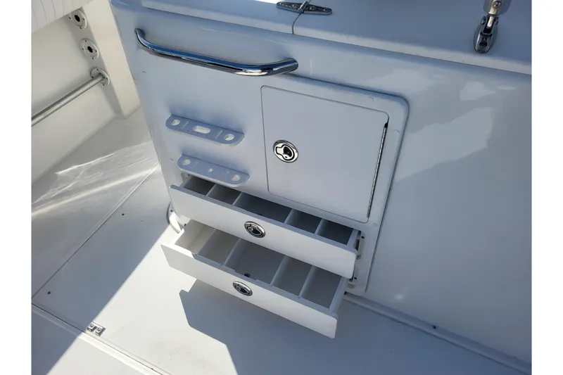 Slide: The Image of 2005 Stamas 310 Tarpon boat storage compartment with open drawers and secure latch. - 89