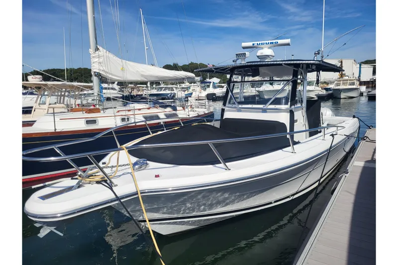 Slide: The Image of 2005 Stamas 310 Tarpon boat docked at a marina under clear blue skies. - 9