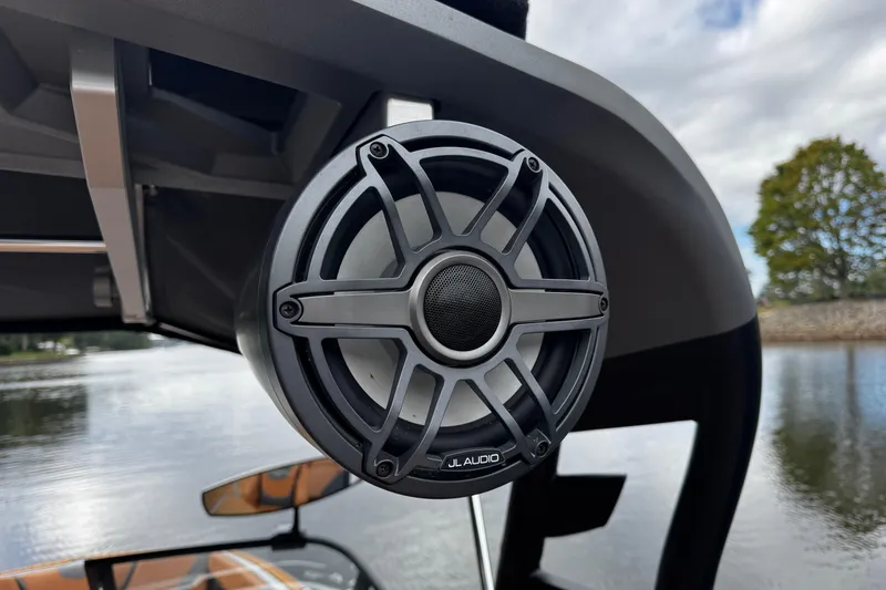 Slide: The Image of JL Audio speaker on 2021 Nautique Super Air Nautique G23 boat, near water. - 12