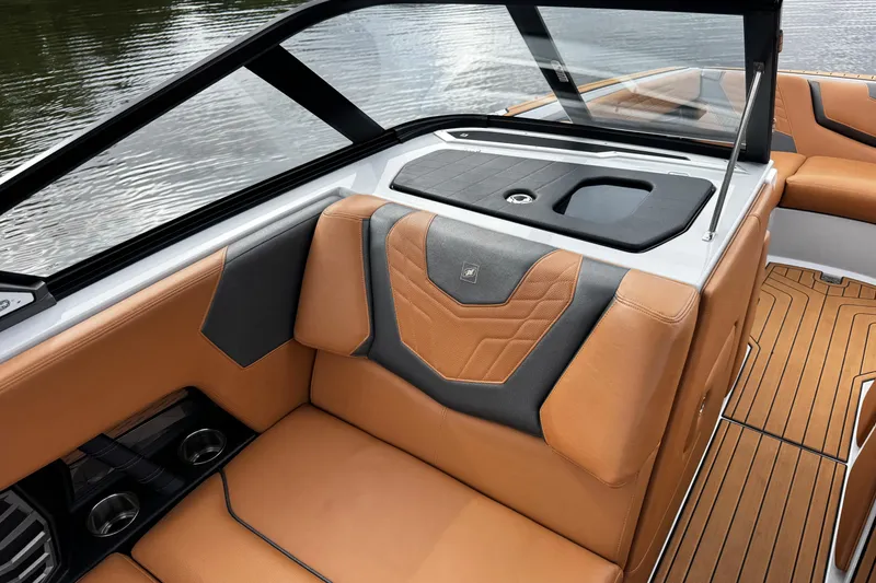 Slide: The Image of 2021 Nautique Super Air Nautique G23 interior with tan and black seating, sleek design. - 16