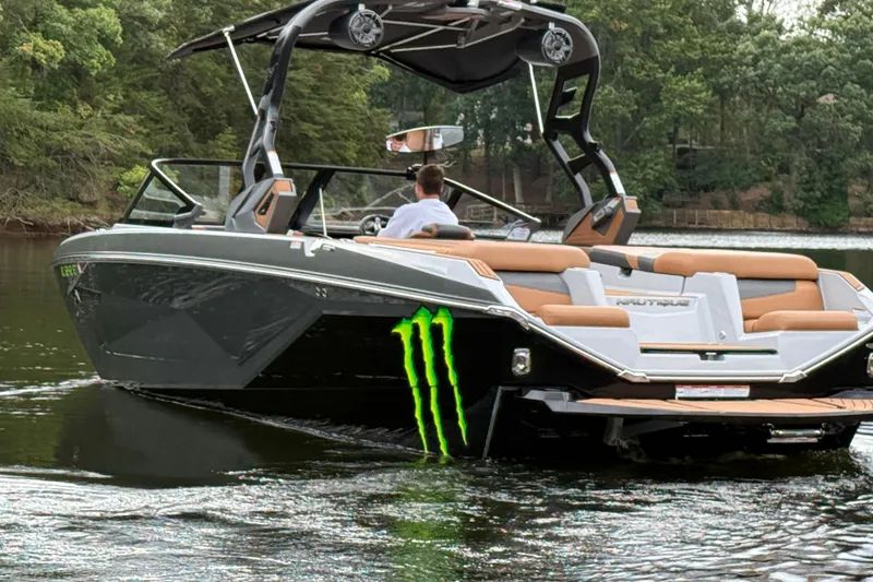 Slide: The Image of 2021 Nautique Super Air Nautique G23 boat on a lake, featuring sleek design and Monster Energy logo. - 5