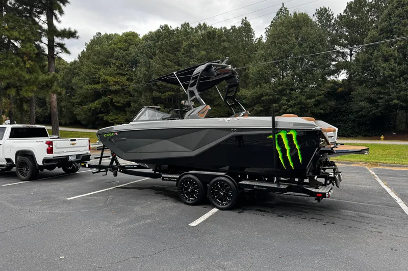 Slide: The Image of 2021 Nautique Super Air Nautique G23 boat on trailer, parked beside a white truck. - 8