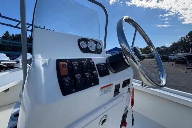 Slide: The Image of 2024 Mako 18 LTS boat console with steering wheel and control panel. - 19