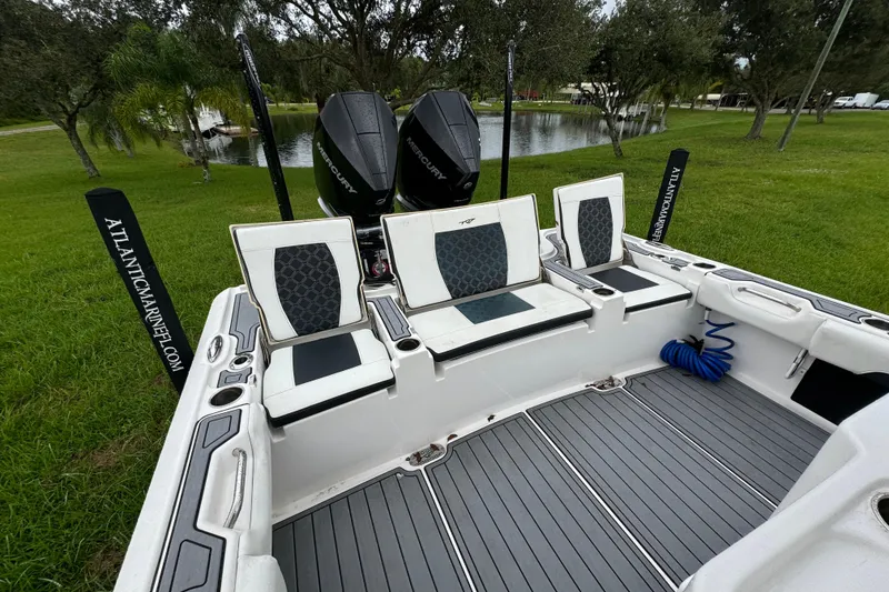 Slide: The Image of 2023 Tidewater 2700 Carolina Bay boat interior with seating and dual Mercury engines. - 10