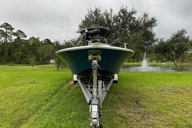 Slide: The Image of 2023 Tidewater 2700 Carolina Bay boat on trailer, parked near a pond with fountain. - 4