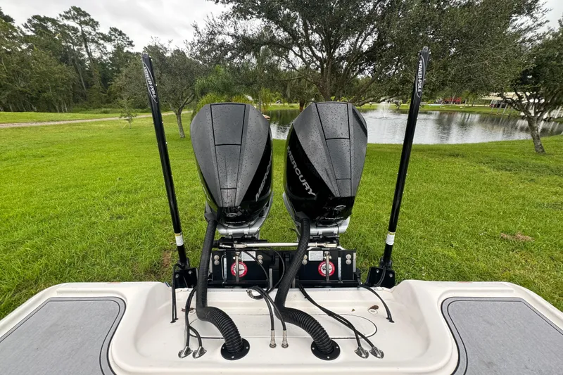 Slide: The Image of 2023 Tidewater 2700 Carolina Bay boat with dual Mercury engines by a pond. - 9