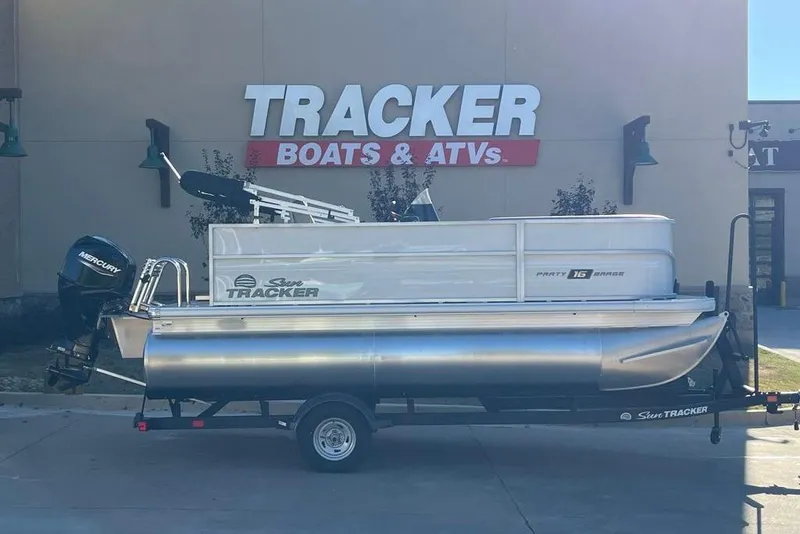 The Image of 2026 Sun Tracker Party Barge 16 DLX pontoon boat on trailer at dealership. - 0