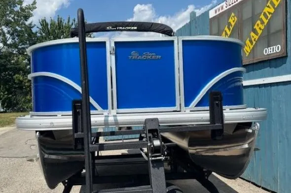 Slide: The Image of 2026 Sun Tracker Party Barge 18 DLX pontoon boat on trailer, blue exterior. - 2