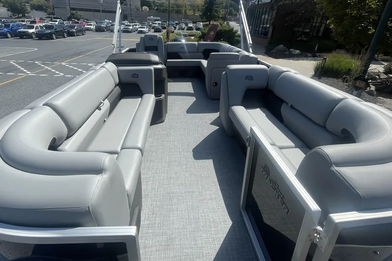 Slide: The Image of 2026 Sun Tracker Party Barge 20 DLX pontoon boat with outboard motor, parked outdoors. - 2