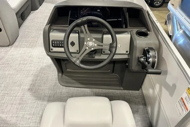 Slide: The Image of 2026 Sun Tracker Party Barge 20 DLX steering console with modern controls and seating. - 6