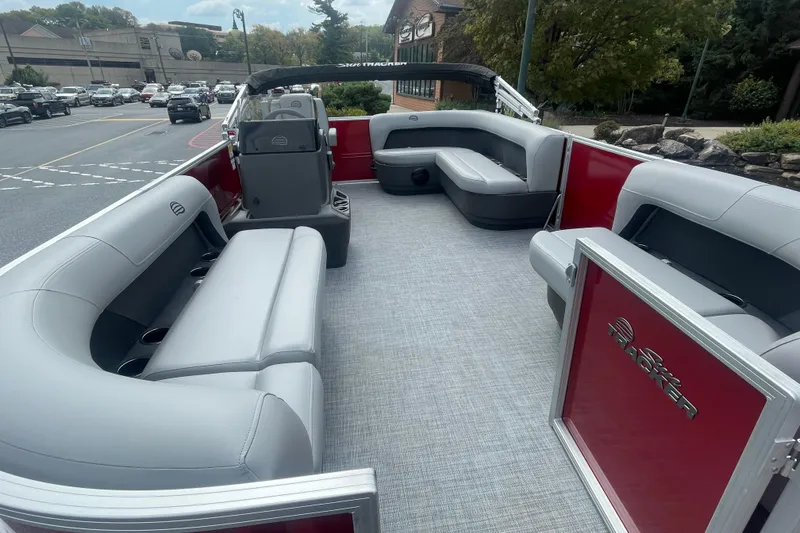 Slide: The Image of 2026 Sun Tracker Party Barge 16 DLX with Mercury engine and ladder, parked outdoors. - 2