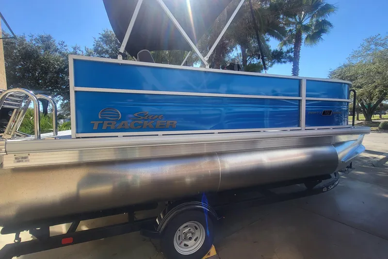 The Image of 2026 Sun Tracker Party Barge 16 DLX pontoon boat, blue exterior, parked outdoors. - 0