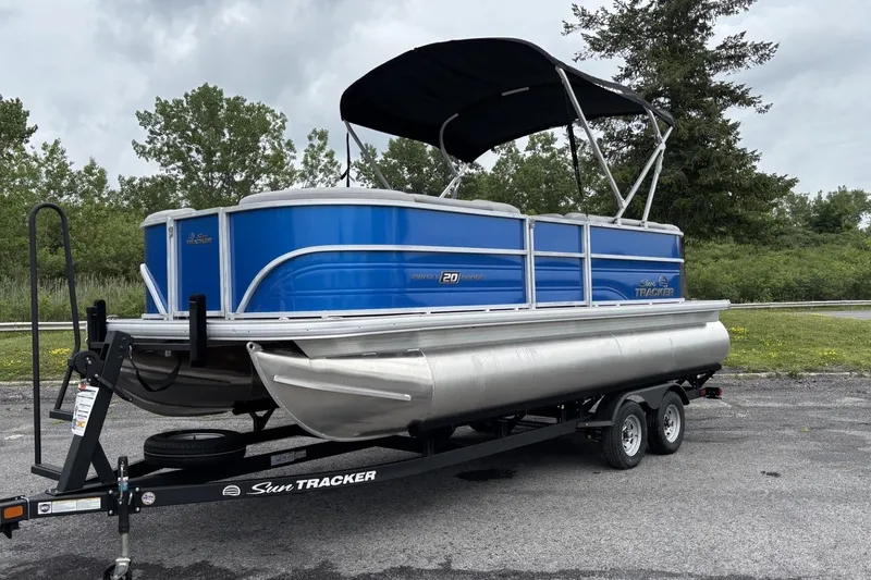The Image of 2026 Sun Tracker Party Barge 20 DLX pontoon boat on trailer, parked outdoors. - 0