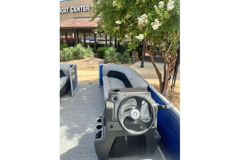 Slide: The Image of 2026 Sun Tracker Party Barge 16 DLX pontoon boat interior with steering console. - 2