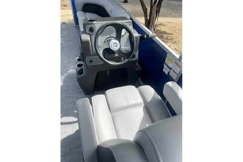 Slide: The Image of 2026 Sun Tracker Party Barge 16 DLX interior with steering wheel and seating. - 3