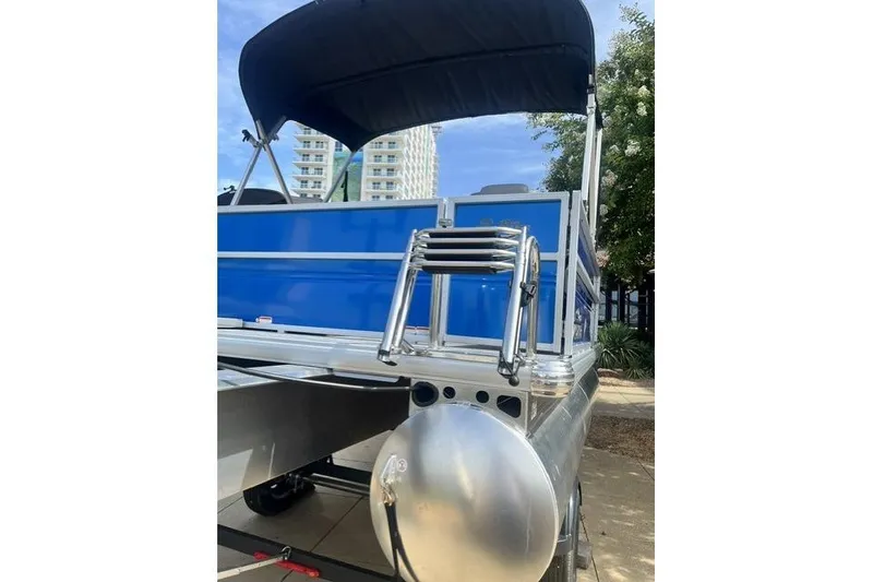Slide: The Image of 2026 Sun Tracker Party Barge 16 DLX pontoon boat with blue panels and canopy. - 7