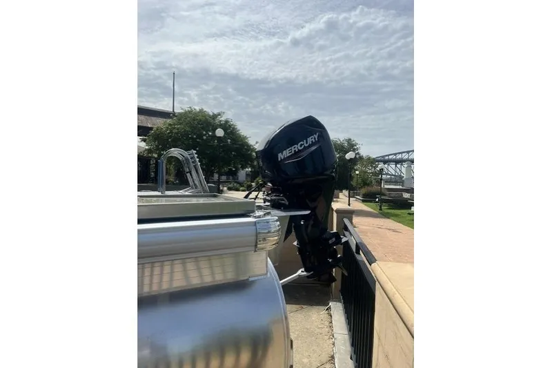 Slide: The Image of 2026 Sun Tracker Party Barge 16 DLX with Mercury outboard motor, docked outdoors. - 8