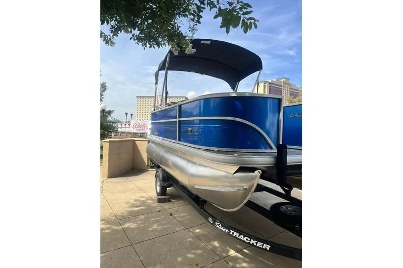 Slide: The Image of 2026 Sun Tracker Party Barge 16 DLX pontoon boat on trailer, blue exterior. - 56