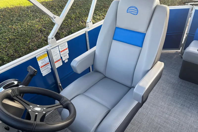 Slide: The Image of 2026 Sun Tracker Party Barge 20 DLX captain's chair and steering wheel, showcasing luxury design. - 16