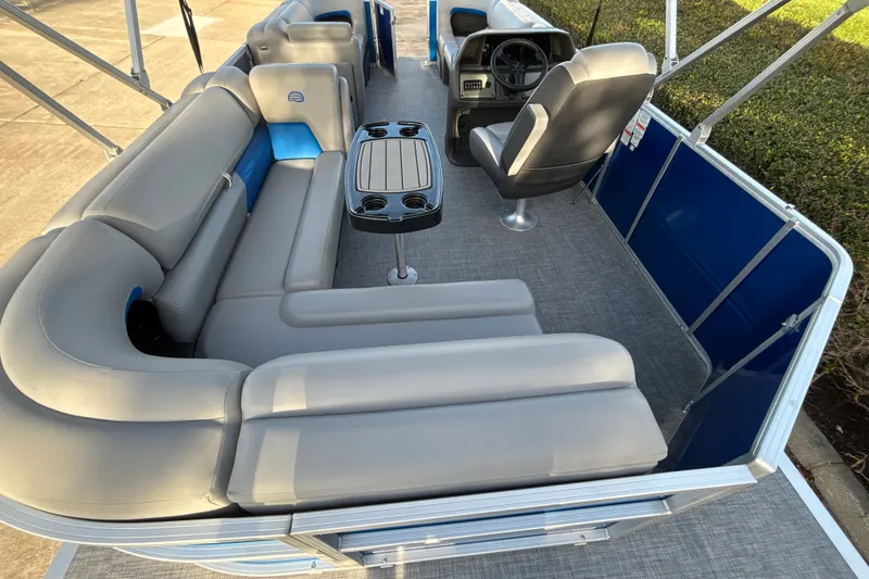 Slide: The Image of 2026 Sun Tracker Party Barge 20 DLX interior with gray seating and steering console. - 14