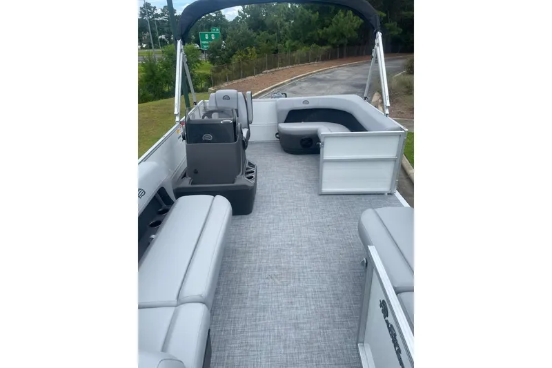 Slide: The Image of 2026 Sun Tracker Party Barge 16 DLX interior with gray seating and open deck layout. - 2