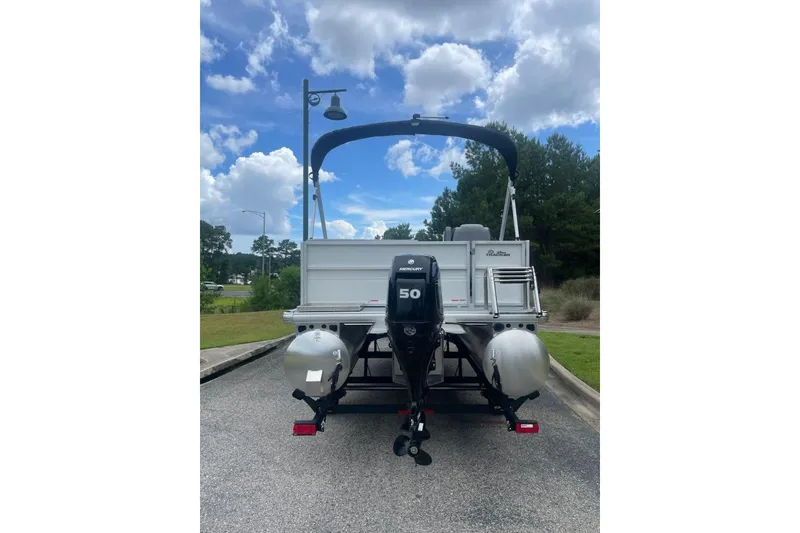 Slide: The Image of 2026 Sun Tracker Party Barge 16 DLX pontoon boat with Mercury 50 engine, parked outdoors. - 3