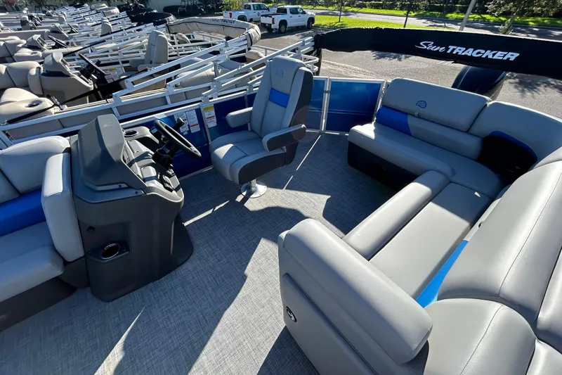 Slide: The Image of 2026 Sun Tracker Party Barge 20 DLX interior with plush seating and steering console. - 4