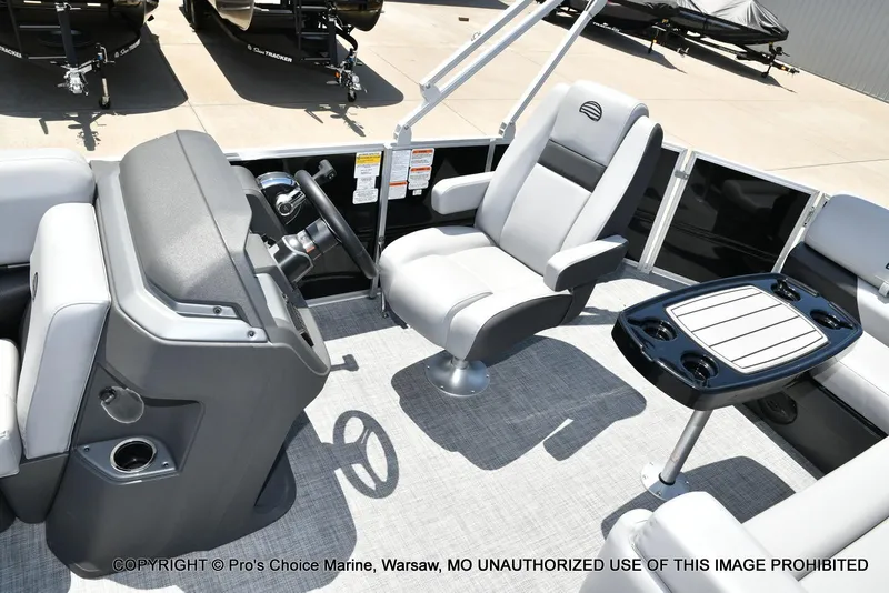 Slide: The Image of 2026 Sun Tracker Party Barge 20 DLX interior with helm, seating, and table. - 70