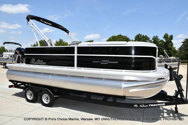 Slide: The Image of 2026 Sun Tracker Party Barge 20 DLX pontoon boat on trailer, parked outdoors. - 73