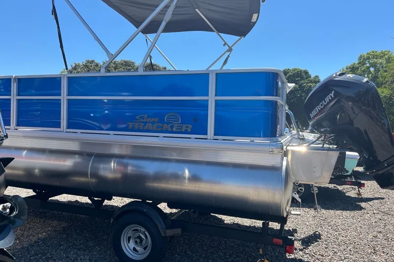 Slide: The Image of 2026 Sun Tracker Party Barge 18 DLX pontoon boat with Mercury engine on trailer. - 2