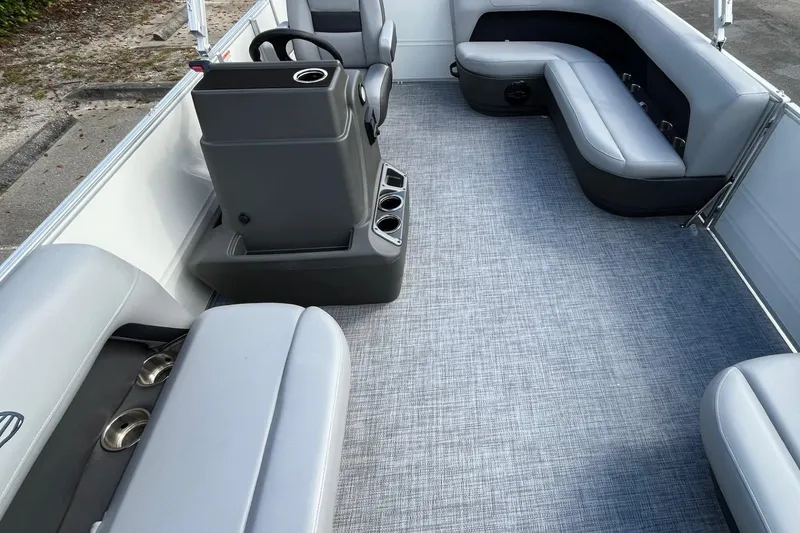Slide: The Image of 2026 Sun Tracker Party Barge 16 DLX interior with gray seating and modern console. - 10