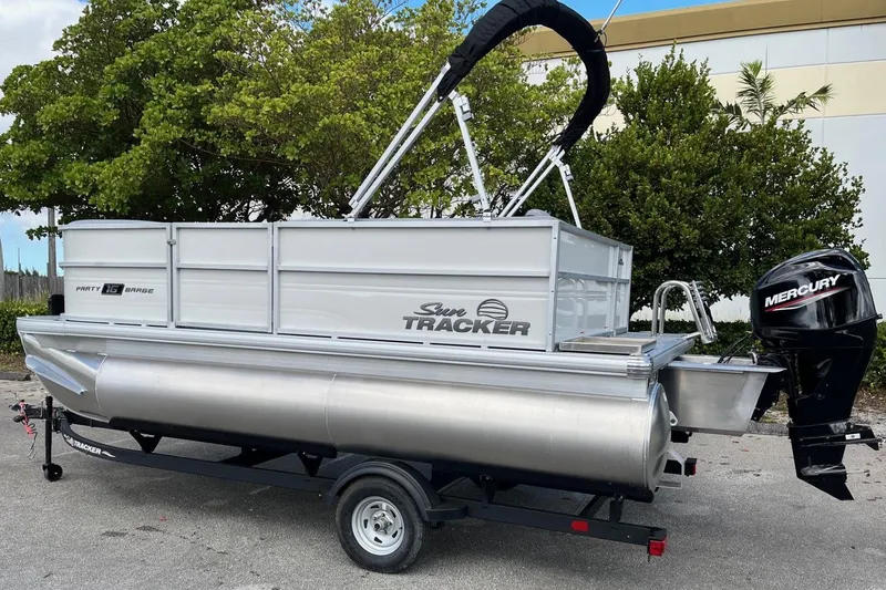 Slide: The Image of 2026 Sun Tracker Party Barge 16 DLX pontoon boat with Mercury outboard motor on trailer. - 4