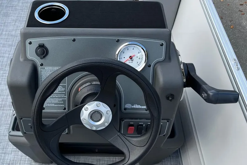 Slide: The Image of Steering console of 2026 Sun Tracker Party Barge 16 DLX with RPM gauge and cup holder. - 7