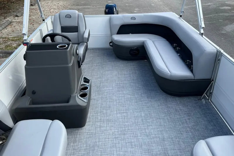 Slide: The Image of 2026 Sun Tracker Party Barge 16 DLX interior with gray seating and steering console. - 8