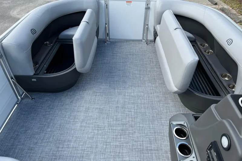 Slide: The Image of 2026 Sun Tracker Party Barge 16 DLX interior with gray seating and cup holders. - 9
