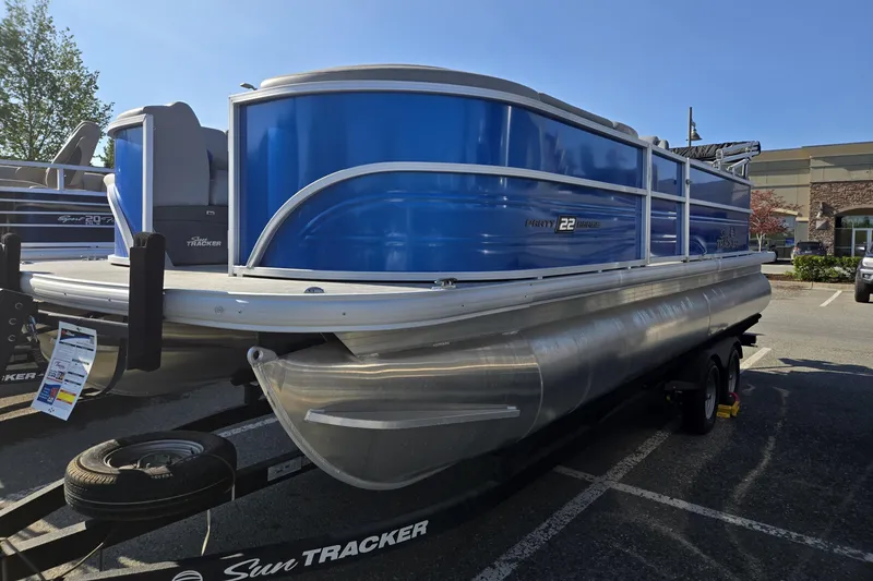 Slide: The Image of 2026 Sun Tracker Party Barge 22 DLX pontoon boat in a parking lot. - 1