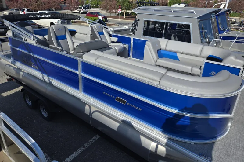 Slide: The Image of 2026 Sun Tracker Party Barge 22 DLX pontoon boat with blue exterior and spacious seating. - 2