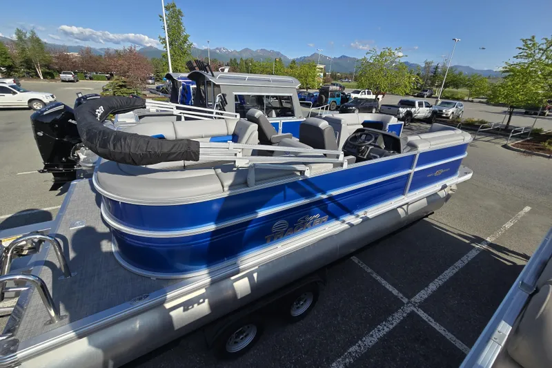 Slide: The Image of 2026 Sun Tracker Party Barge 22 DLX pontoon boat in parking lot, blue exterior. - 4