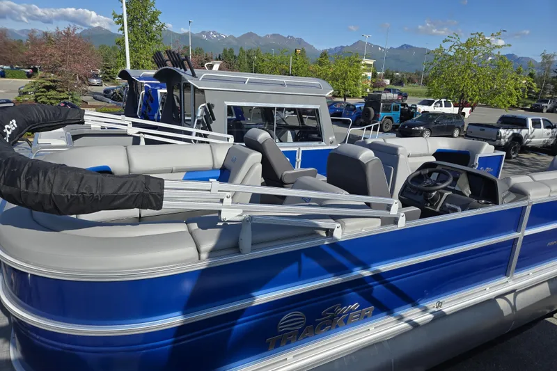 Slide: The Image of 2026 Sun Tracker Party Barge 22 DLX pontoon boat in a parking lot with mountains in background. - 3