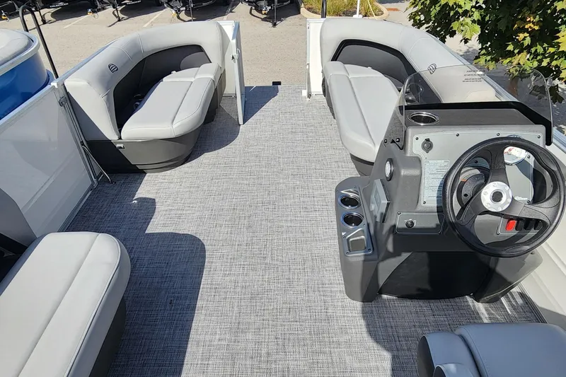 Slide: The Image of 2026 Sun Tracker Party Barge 16 DLX interior with seating and steering console. - 3