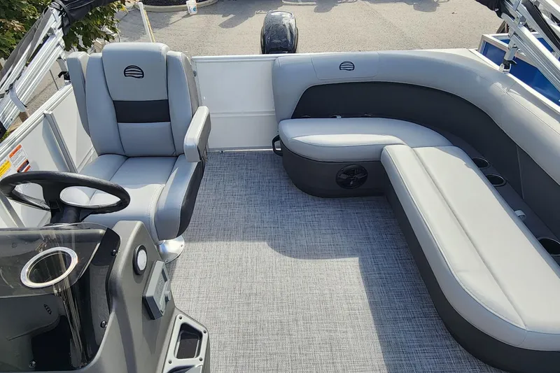 Slide: The Image of 2026 Sun Tracker Party Barge 16 DLX interior with gray seating and steering console. - 4