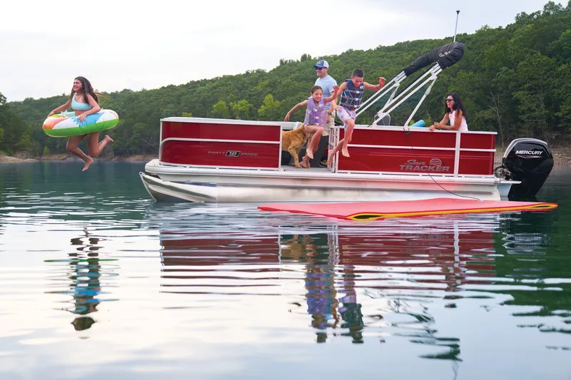 Slide: The Image of 2026 Sun Tracker Party Barge 18 DLX with Mercury outboard motor, parked outdoors. - 5