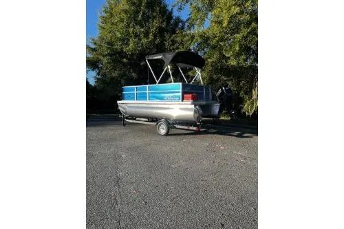 Slide: The Image of 2026 Sun Tracker Party Barge 16 DLX pontoon boat on trailer, parked outdoors. - 3