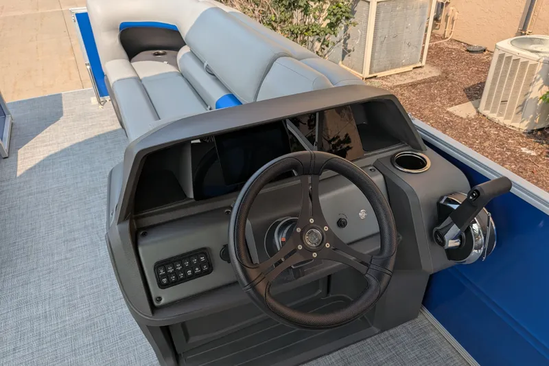 Slide: The Image of 2026 Sun Tracker Party Barge 20 DLX helm with steering wheel and controls. - 81