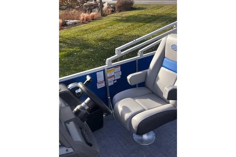 Slide: The Image of 2026 Sun Tracker Party Barge 20 DLX interior with captain's chair and steering wheel. - 71