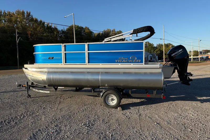 The Image of 2026 Sun Tracker Party Barge 16 DLX pontoon boat on trailer, parked outdoors. - 0