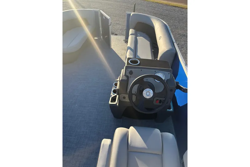 Slide: The Image of 2026 Sun Tracker Party Barge 16 DLX interior with steering wheel and seating. - 4