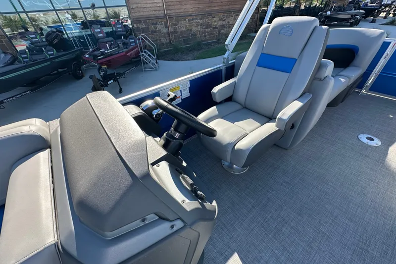 Slide: The Image of 2026 Sun Tracker Party Barge 22 DLX interior with steering console and comfortable seating. - 52